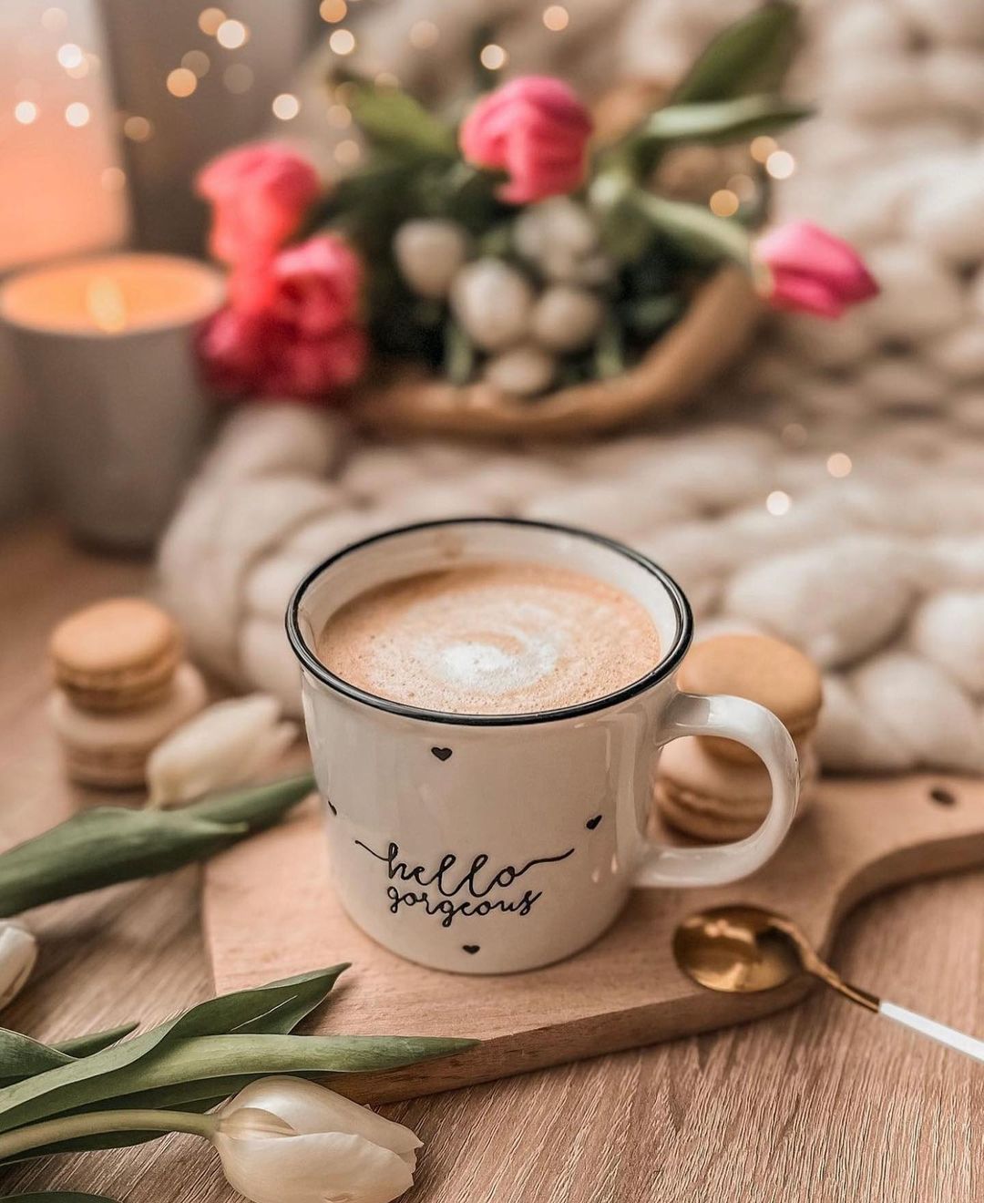 Фото Чашка с кофе стоит на досточки и рядом лежат белые тюльпаны