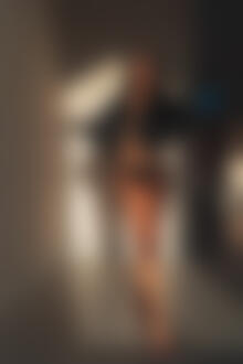 Фото Длинноволосая девушка в трусиках и кожаной курточке стоит в комнате