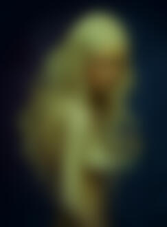 Фото Обнаженная девушка - блондинка с длинными волосами на синем фоне