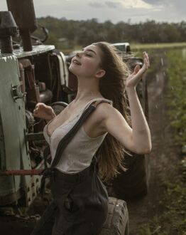 Фото Девушка трактористка радуется дождю