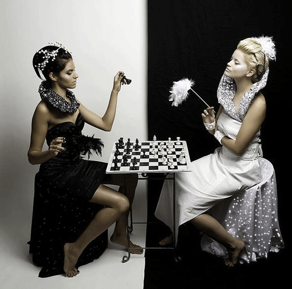 Анимация Девушка в черном и девушка в белом играют в шахматы, гифка Девушка в черном и девушка в белом играют в шахматы
