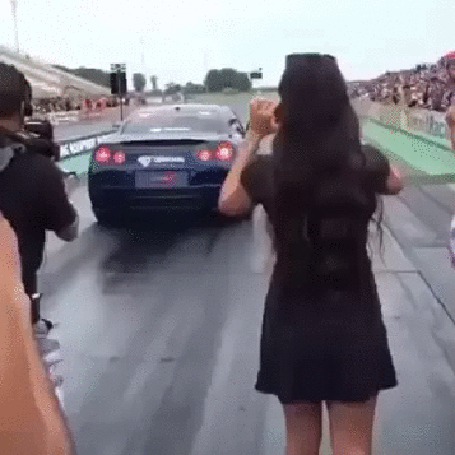 Анимация У девушке, снимающий автогонки, поток воздуха от проезжающей рядом машины приподнимает платье