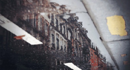 Анимация Капли дождя падают в лужу, в которой отражается старинное здание