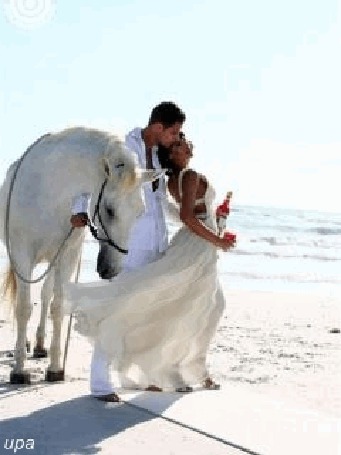 Анимация Мужчина прижимается к женщине, которая держит в руке бутылку вина, около них стоит красивый белый конь, а их взгляду открываются голубое небо и теплое море, upa