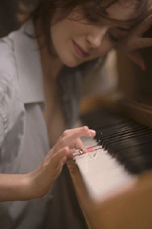 Анимация Девушка, нажав на клавишу пианино, смотрит на появляющиеся сердечки