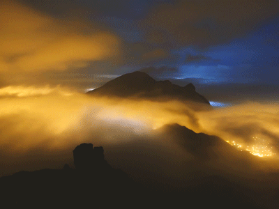 Анимация Облака проплывают над горой и ночным городом, гифка Облака проплывают над горой и ночным городом