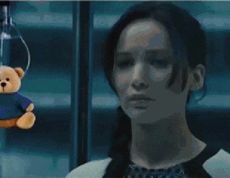 Анимация Китнисс Эвердин / Katniss Everdeen из фильма Голодные игры / The Hunger Games, актриса Дженнифер Лоуренс / Jennifer Lawrence, пытается достать плюшевого медведя из автомата с игрушками