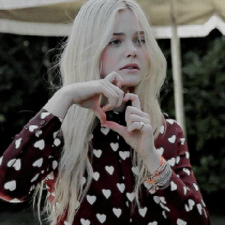 Анимация Elle Fanning / Эль Фаннинг показывает руками разламывающееся сердечко и смеется
