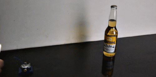 Анимация Мини-пушка стреляет по бутылке пива Корона / Corona, гифка Мини-пушка стреляет по бутылке пива Корона / Corona