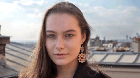 Анимация Девушка с серьгами стоит на фоне неба