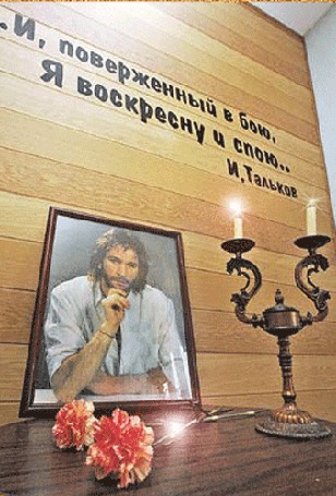 Анимация Портрет Игоря Талькова рядом с двумя свечами в подсвечнике и двумя гвоздиками на столе (И, поверженный в бою, Я воскресну и спою. И. Тальков)