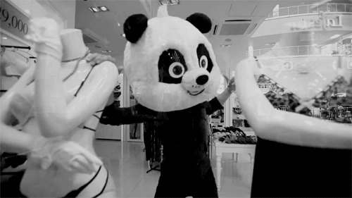Анимация Человек в костюме панды танцует в магазине с манекенами, гифка Человек в костюме панды танцует в магазине с манекенами
