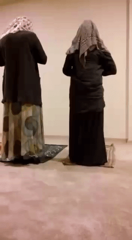 Анимация Во время молитвы одна из женщин падает на руки, пугая при этом рядом другую, гифка Во время молитвы одна из женщин падает на руки, пугая при этом рядом другую