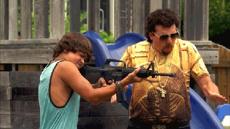 Анимация Комичный актер Kenny Powers / Кенни Пауэрс стоит рядом с мальчишкой, который строчит из автомата, возле горки на детской площадке