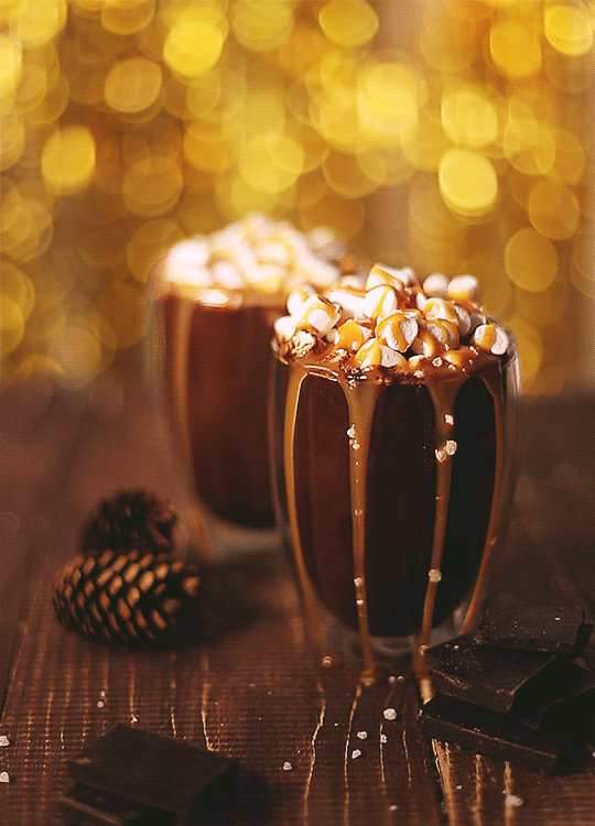 Анимация Два стакана горячего шоколада с маршмеллоу на столе с шишками, на фоне золотистых бликов боке, by Daria Khoroshavina, гифка Два стакана горячего шоколада с маршмеллоу на столе с шишками, на фоне золотистых бликов боке, by Daria Khoroshavina