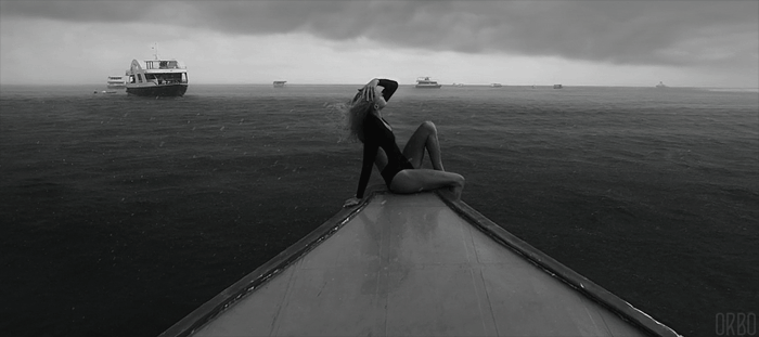 Анимация Девушка сидит на краю корабля под дождем, гифка Девушка сидит на краю корабля под дождем