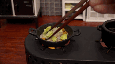 Анимация Поджаривание кусочков пищи на небольшой сковородке с помощью палочек, гифка Поджаривание кусочков пищи на небольшой сковородке с помощью палочек