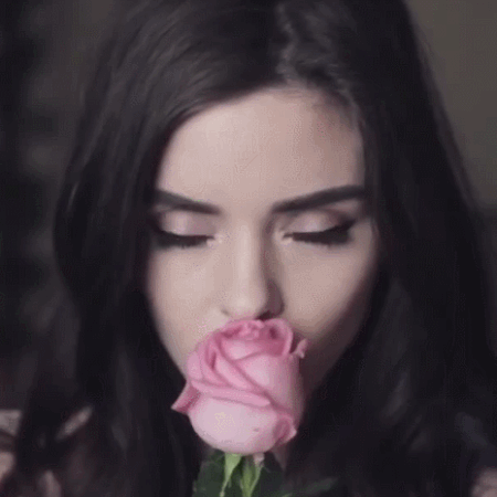 Анимация Красивая девушка держит розу и улыбается, гифка