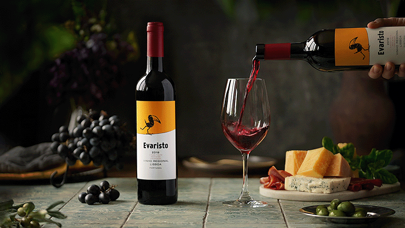 Анимация В бокал, стоящий рядом с бутылкой, тарелкой с сырами, маслинами и виноградом, наливают вино, гифка