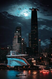 Обои на телефон Гуанчжоу / Guanchzhou, Китай / China: современный стадион с синей подсветкой и освещенные небоскребы в ночном городе на фоне темного неба с полной луной и облаками