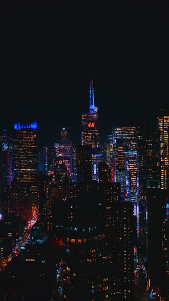 обои на телефон Ночной Манхэттен / Manhattan, США / USA, с множеством подсвеченных небоскребов и зданий, одно из которых имеет логотип (H&M), на фоне темного ночного неба