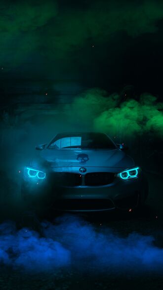 обои на телефон Серебряный автомобиль BMW M3 с включенными ярко-голубыми фарами стоит на темной поверхности, на фоне синего и зеленого дыма