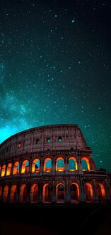 Обои на телефон Колизей / Colosseum, Рим / Rome, Италия / Italy, древний амфитеатр освещен оранжевым светом, на фоне звездного неба с бирюзовым оттенком