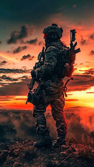 Обои на телефон Мужчина в военном костюме и шлеме с винтовкой на плече на каменистой поверхности на фоне яркого оранжево-красного заката с облаками
